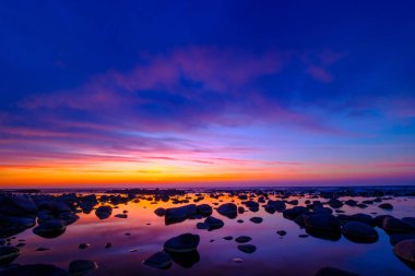 Güzel gün batımı taşlarla deniz yan