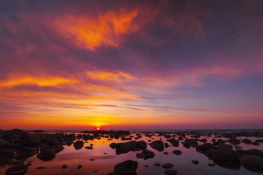 Güzel gün batımı taşlarla deniz yan