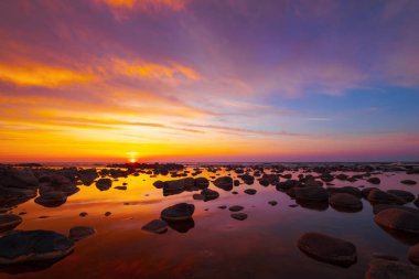 Güzel gün batımı taşlarla deniz yan