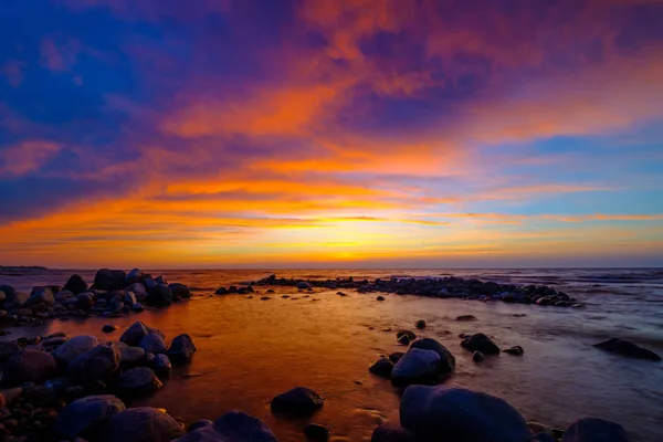 Pôr do sol bonito no lado do mar com pedras — Fotografia de Stock