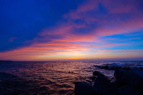 Hermosa puesta de sol en el lado del mar con piedras — Foto de Stock