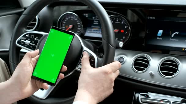 Hombre usando el teléfono inteligente en el fondo de un panel de clase de lujo del coche — Vídeo de stock