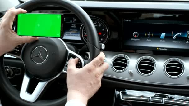 Hombre usando el teléfono inteligente en el fondo de un panel de clase de lujo del coche — Vídeo de stock