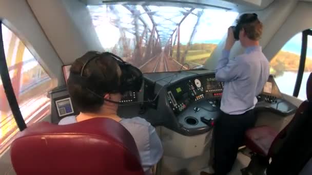 Мужчины учатся водить поезд на тренажере виртуальной реальности — стоковое видео