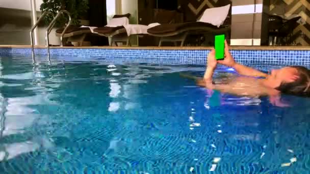 Мужчина средних лет использует смартфон в бассейне — стоковое видео