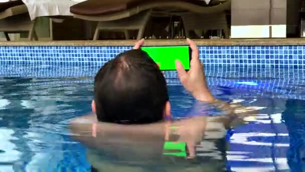 Hombre de mediana edad usando smartphone en la piscina — Vídeos de Stock