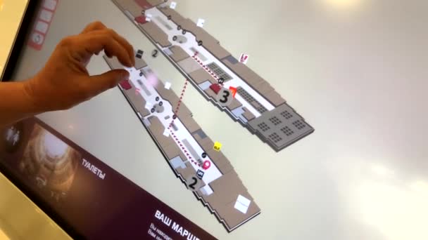 Shopper studies a mall layout at a self-service touch screen kiosk — Stock Video