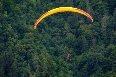 Bulutlu gökyüzünde uçan tandem yamaç paraşütü