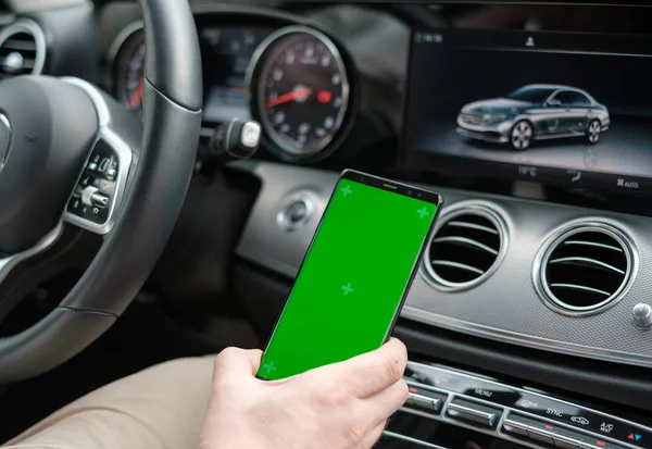 Člověk používající smartphone na pozadí přístrojové desky pro automobily s luxusní třídou — Stock fotografie