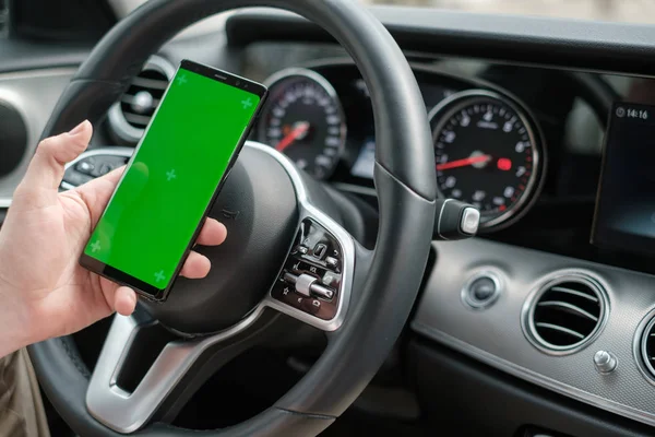 Ember használ okostelefon a háttérben egy luxus osztályú autó műszerfal — Stock Fotó