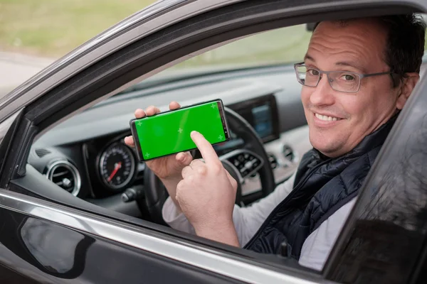 Middle age man shows smartphone with chromakey screen — Stock Photo, Image
