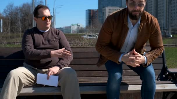 Two men exchange envelope outdoors — Stock Video