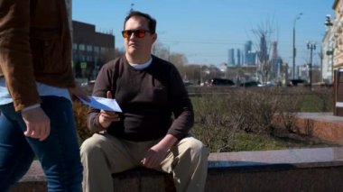 İki adam açık havada zarf değişimi