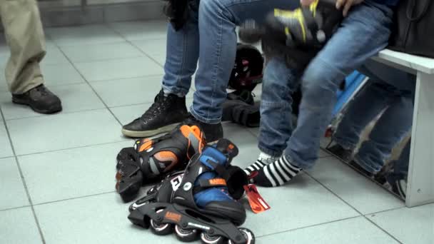 Moeder en zoon proberen op sportschoenen en rolschaatsen in een sportwinkel — Stockvideo