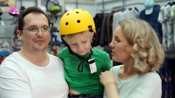 Lycklig familj väljer cykel hjälm för son — Stockvideo