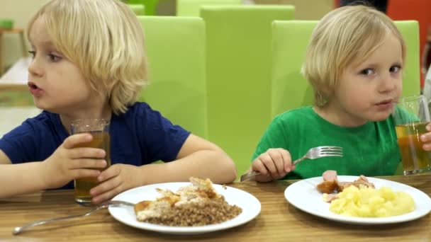 Jongens broers eten lunch in de keuken — Stockvideo