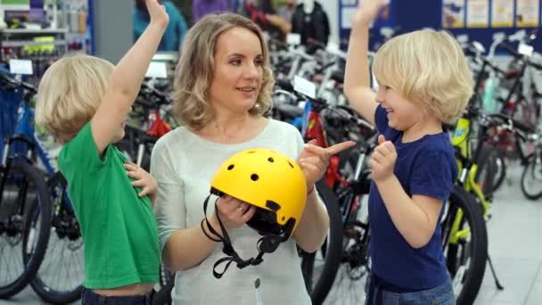 Madre eligiendo casco de bicicleta para los hijos — Vídeos de Stock