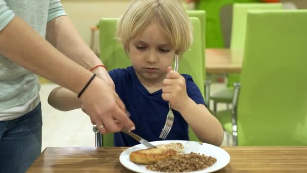 Mamma lär sonen att använda en kniv och gaffel — Stockvideo