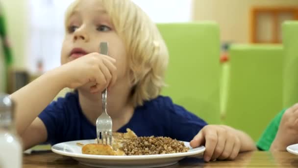 Boys brothers eat lunch at the kitchen — Stock Video