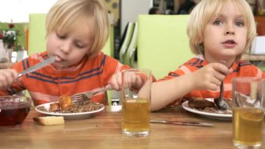 Erkek kardeşler mutfakta öğle yemeği yiyor