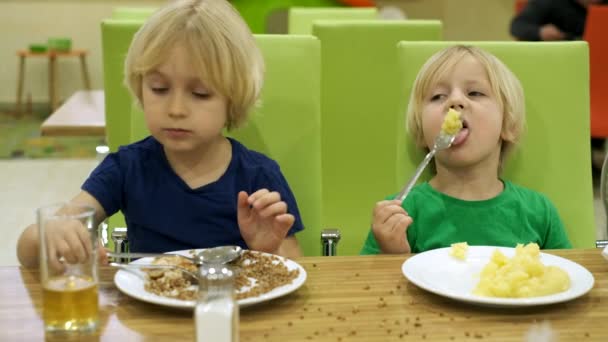 Hermanos chicos almorzan en la cocina — Vídeos de Stock