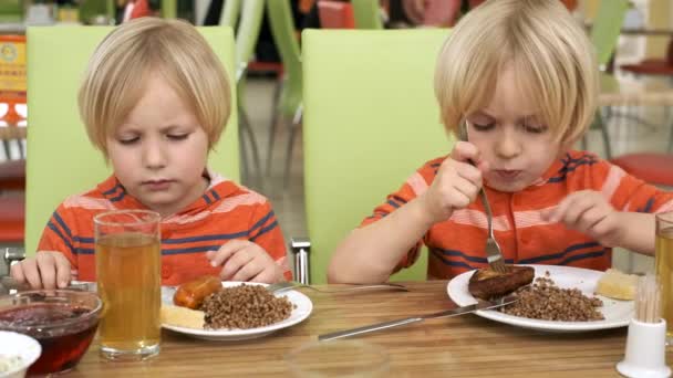 Hermanos chicos almorzan en la cocina — Vídeos de Stock