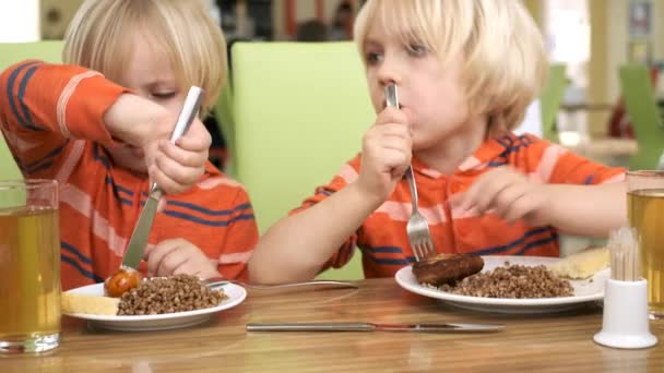 Мальчики-братья обедают на кухне — стоковое видео