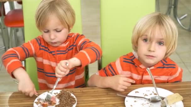 Мальчики-братья обедают на кухне — стоковое видео