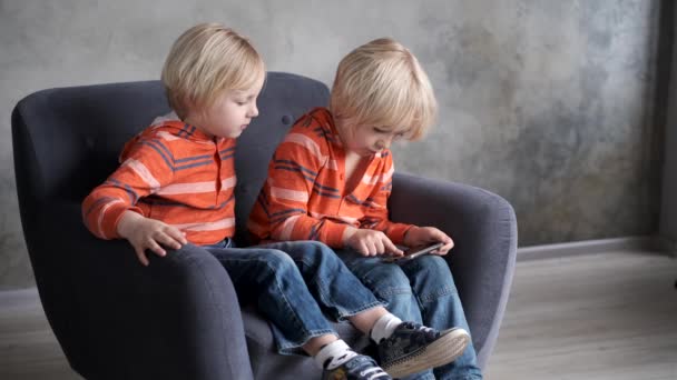 Los hermanos están viendo o jugando o aprendiendo algo en un teléfono inteligente — Vídeo de stock