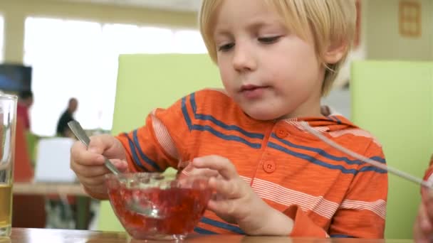 Мальчик обедает за столом на кухне — стоковое видео