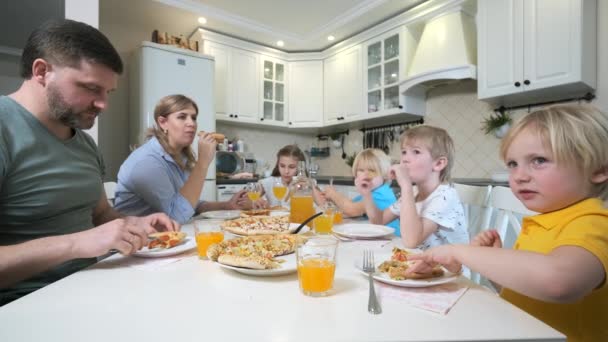 Gezin met kinderen die pizza aan tafel eten — Stockvideo