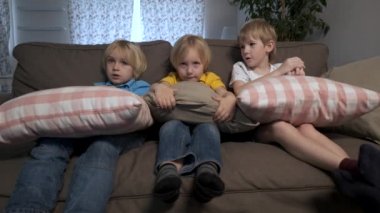 Erkek çocuklar kardeşler kanepeye oturup Tv izle