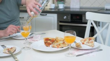 Adam masada pizza yiyor.