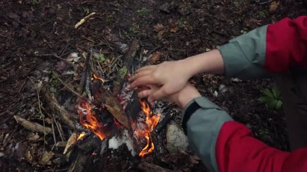 Muž ohřívají ruce nad ohněm — Stock video