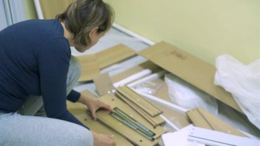 Beyaz orta yaş kadın mobilya montajı olduğunu