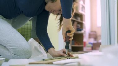 Beyaz orta yaş kadın mobilya montajı olduğunu