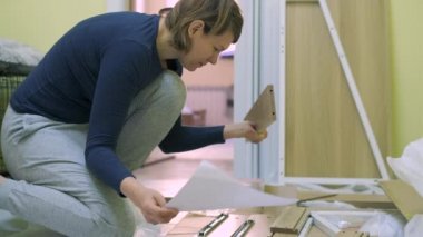 Beyaz orta yaş kadın mobilya montajı olduğunu