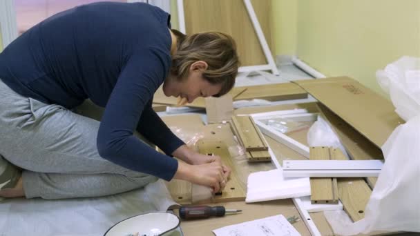 White middle age woman is assembling furniture — Stock Video