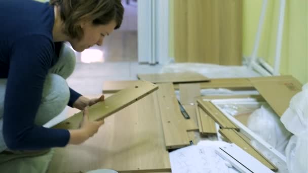 Witte middelbare leeftijd vrouw is het monteren van meubels — Stockvideo