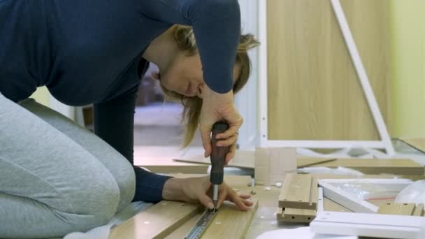 Witte middelbare leeftijd vrouw is het monteren van meubels — Stockvideo