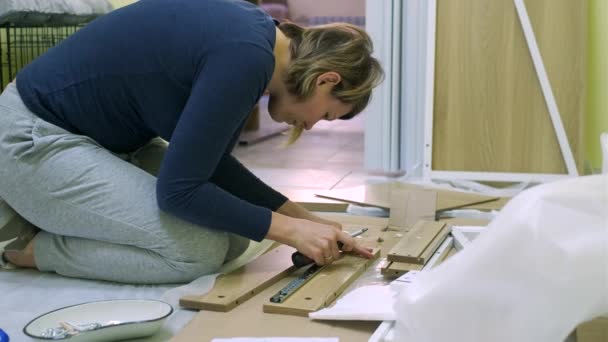 白人中年女性が家具を組み立てている — ストック動画