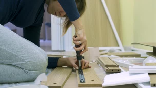 Witte middelbare leeftijd vrouw is het monteren van meubels — Stockvideo