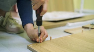 Beyaz orta yaş kadın mobilya montajı olduğunu