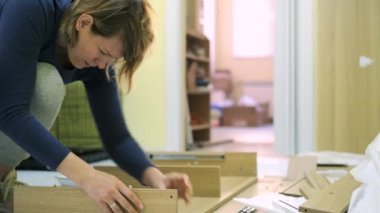 Beyaz orta yaş kadın mobilya montajı olduğunu