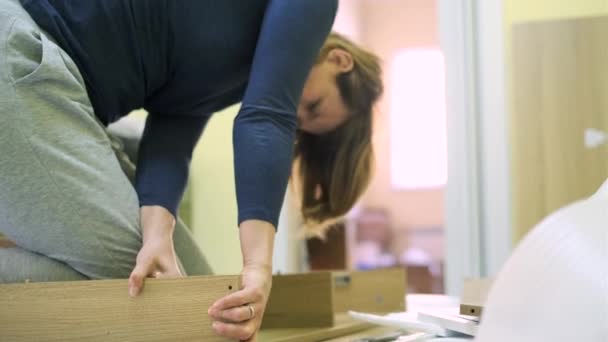 Mujer blanca de mediana edad está montando muebles — Vídeo de stock