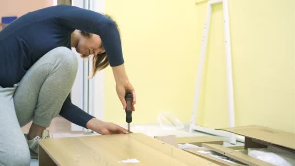 Vit medelålders kvinna monterar möbler — Stockvideo