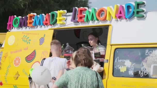 Jonge vrouw verkoopt verse zelfgemaakte limonade van voedsel track — Stockvideo