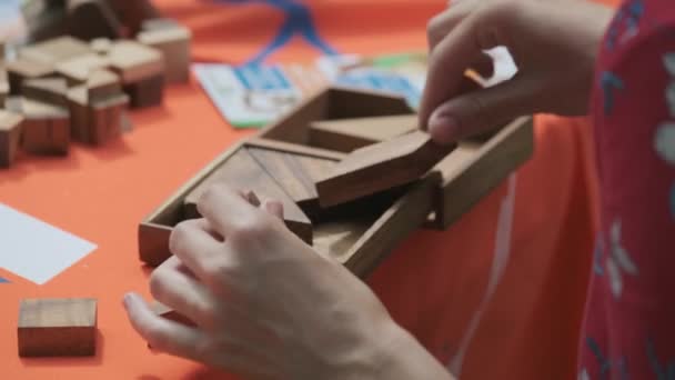 Mulher está combinando quebra-cabeça de madeira — Vídeo de Stock