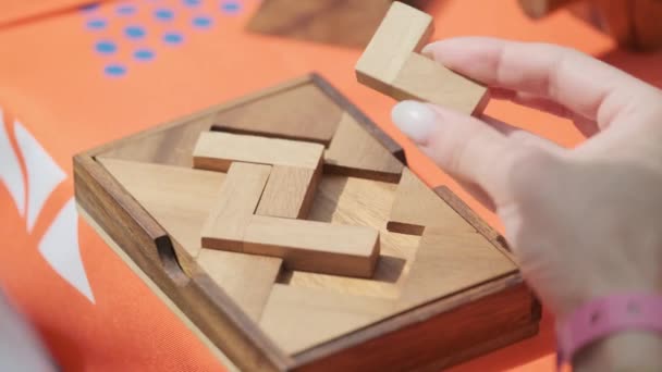 Женщина соединяет деревянную головоломку — стоковое видео