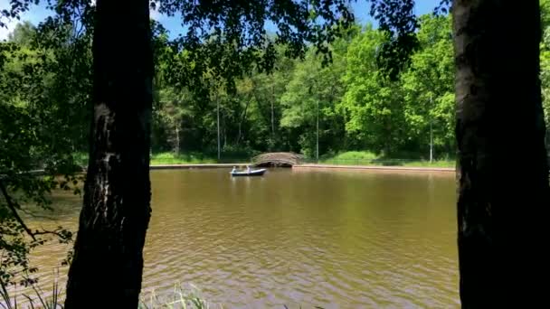 Люди катаются на лодке по озеру — стоковое видео